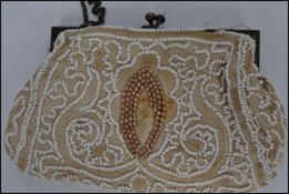 A vintage early 20th century ladies embroidery purse adorned with white and gilt beads.