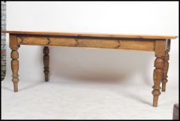 A large Victorian refectory country oak dining table being raised on turned reeded baluster legs
