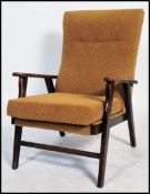 A 1950's fireside armchair having a chintzy gold upholstery raised on angular legs.