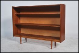A 1970's retro teak wood open window bookcase cabinet with tapering legs to the base, shelves to