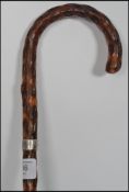 A silver collared early 20th century Victorian blackthorn walking stick of tapering form with curved