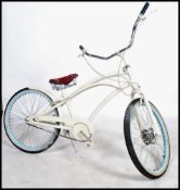 A vintage 20th century fixed speed beech cruiser bike, having an over sized low saddle, sweeping