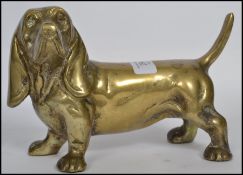 An early 20th century brass door stop in the form of a standing dog. Measures 14cms high.