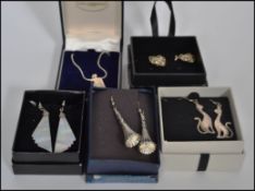Four pairs of silver white metal earrings to include figural cat pair, mother of pearl drop pair,