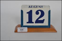 A vintage 20th century retro industrial desk top calendar raised on a plinth base with blue metal