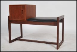 A vintage teak wood telephone table having a telep