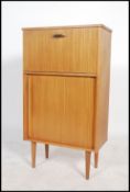 A 1970's retro teak wood cocktail cabinet with metamorphic action mirror glass appointed interior
