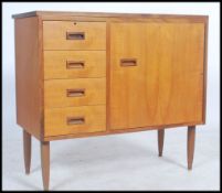 A 1970's retro teak wood  sideboard sewing cabinet raised on turned legs with flip over top over a