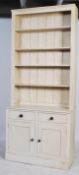 A contemporary 20th century painted pine dresser / bookcase cabinet. Having an open bookcase top