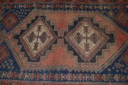 A 20th century Persian rug of Islamic form having twin medallions to centre with geometric red and