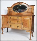 A large 1930's solid oak sideboard comprising a series of cupboards and short drawers with stage