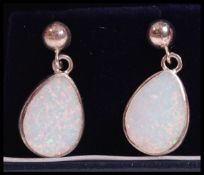 A pair of silver and opal ladies earrings, each of