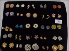 A group of 25 pairs of clip on earrings to include gilt pairs, rhinestone, mother of pearl, floral