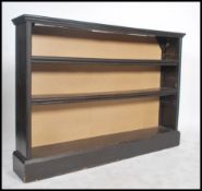 A Victorian ebonised open window bookcase cabinet being raised on a plinth base with fixed