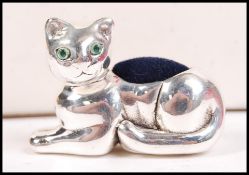 A silver pin cushion in the form of a seated cat h