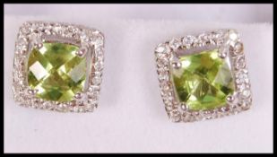 A pair of ladies silver, cz and peridot adorned ea