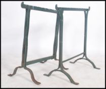 A pair of green painted workmen's trestle stands,