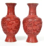 A pair of Oriental cinnabar lacquer cloisonne vases carved with scrolls and flowers depicting five