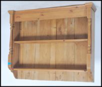 A 20th century pine wall hanging display unit having fixed shelves with turned columns supports.