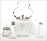A group of silver topped and plated cut glass items to include a biscuit barrel with swing handle