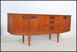 A 1970's Danish teak wood sideboard being raised on tapering legs with twin cupboard, bank of