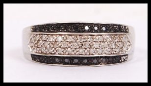 A 9ct white gold, black and white diamond ring  be