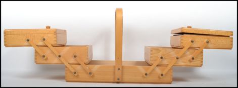 A mid 20th century teak wood metamorphic work box / sewing box. Having hinged lids with multiple