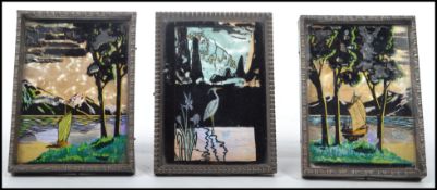 A group of three miniature mother of pearl and butterfly wing panels depicting birds, ships and