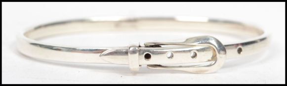A sterling silver bangle bracelet in the form of a belt and buckle marked 925, weighs 15.4 grams.