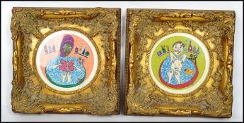 A pair of framed and glazed comic needle point pictures of people in the bath tub by artist Sarah