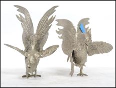 A vintage 20th century pair of large silver plate fighting cocks - cockerels, both in differing