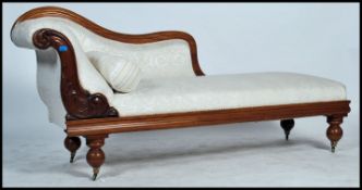 A 19th century Victorian mahogany chaise lounge raised on turned legs with brass castors and