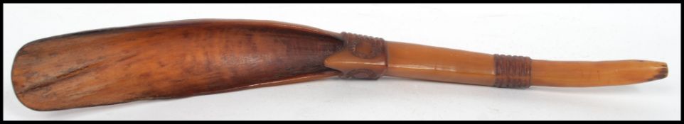 A 19th Century carved horn gun powder scoop having a shaped handle. Measurements: 31 cm high, 4 cm