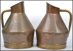 A pair of large early 20th century copper and brass ewer /grog jugs having shaped tubular handles