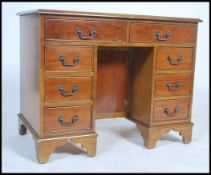 A 20th century antique style yew wood and gilt tooled green leather inset twin pedestal kneehole