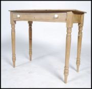 A Victorian country pine writing table being raised on tapered legs with single frieze drawer and