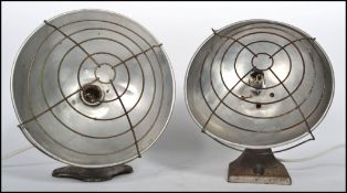 A near pair of 1960s polished steel heat lamps with wire cages being converted to table lamps