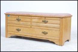 An Edwardian ash wood arts and crafts window seat having upholstered seat over short and deep