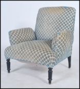 A Victorian armchair having a sprung cushioned seat with shaped cushion armrests raised on turned