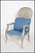 A 20th Century French carved framed Fauteuil bergere chair, having a contemporary silver painted