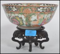 An early 20th century Cantonese rose medallion bowl with cartouche panels depicting domestic scenes,