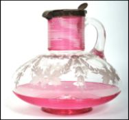 An early 19th century Georgian cranberry glass  claret ewer jug having a silver hallmarked lid.