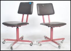 A pair of swivel chairs in red vinyl on four star