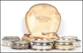 A trio of silver hallmarked napkin rings, a matching pair of silver hallmarked napkin rings, a