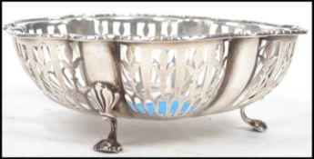 A 20th century hallmarked silver bowl raised on tripod cabriolet legs with pierced window sides