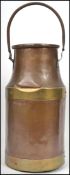 A large early 20th century agricultural copper and brass dairy milk churn with looped swing handle