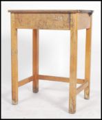 A mid 20th century beech wood school desk with lift-up lid, supported on square legs. Measures 76cms