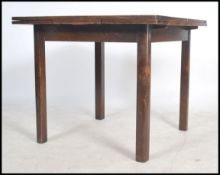 A 1940's utilty oak draw leaf dining table being raised on chamfered edge squared legs with