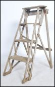A vintage 20th century Industrial trestle sides wooden step ladder of a-frame style with stepped