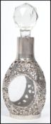 A sterling silver perfume bottle having a chased floral decoration with a faceted glass stopper with